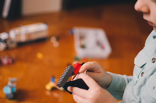 A boy plays with lego bricks.